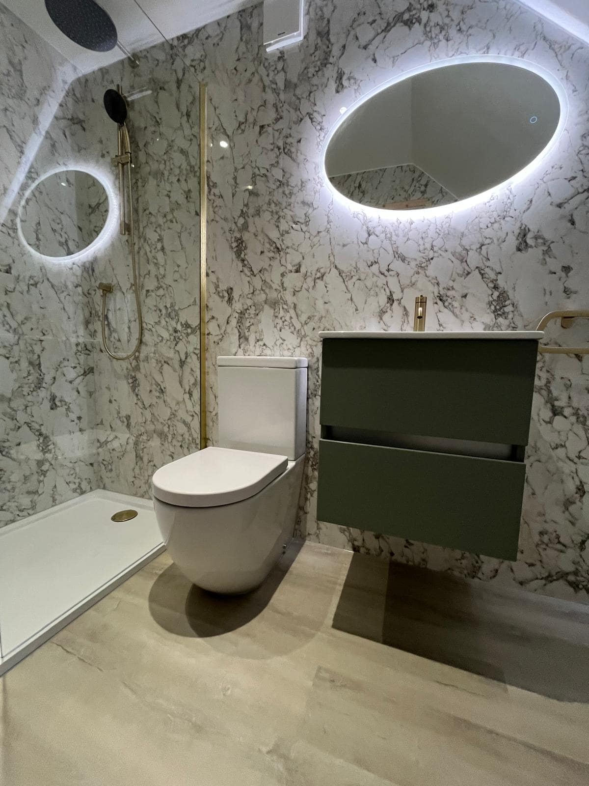 Gallery Wall-mounted vanity unit with illuminated mirror beside a toilet and walk-in shower