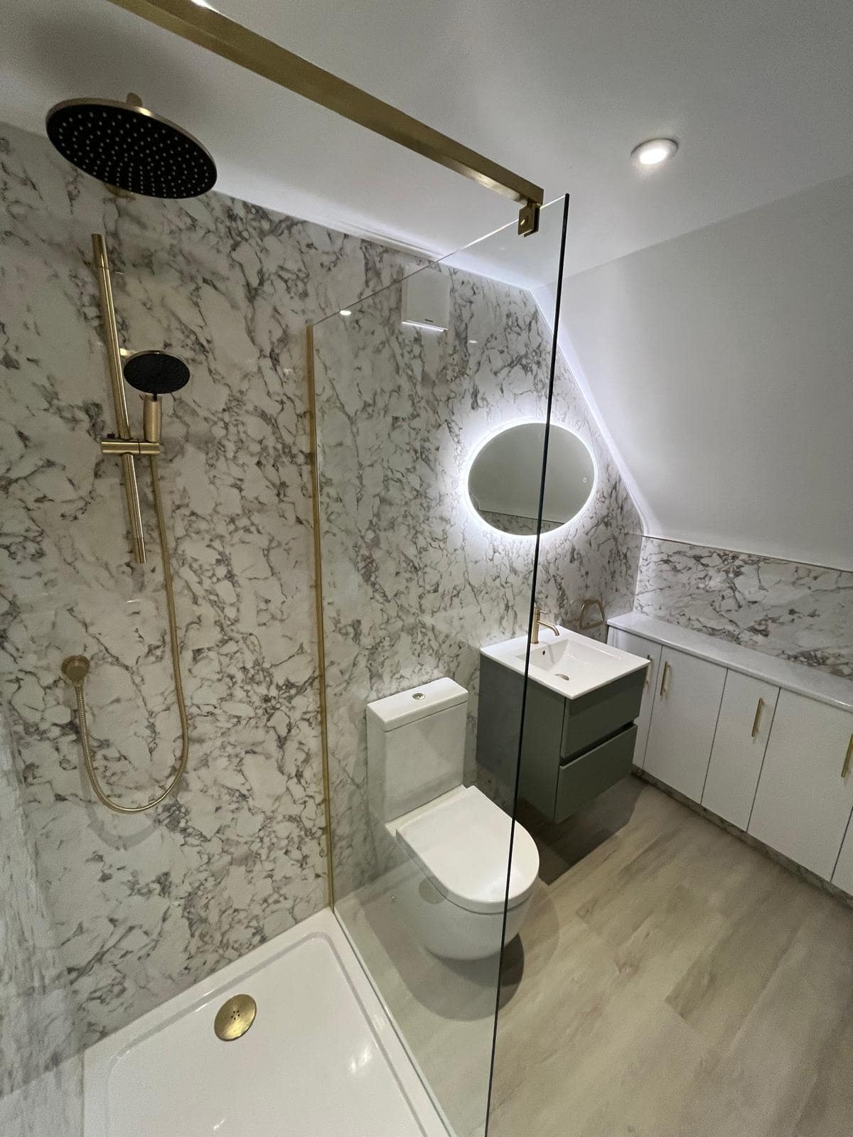 Gallery Walk-in shower with glass screen and wall-mounted controls beside a toilet and vanity unit
