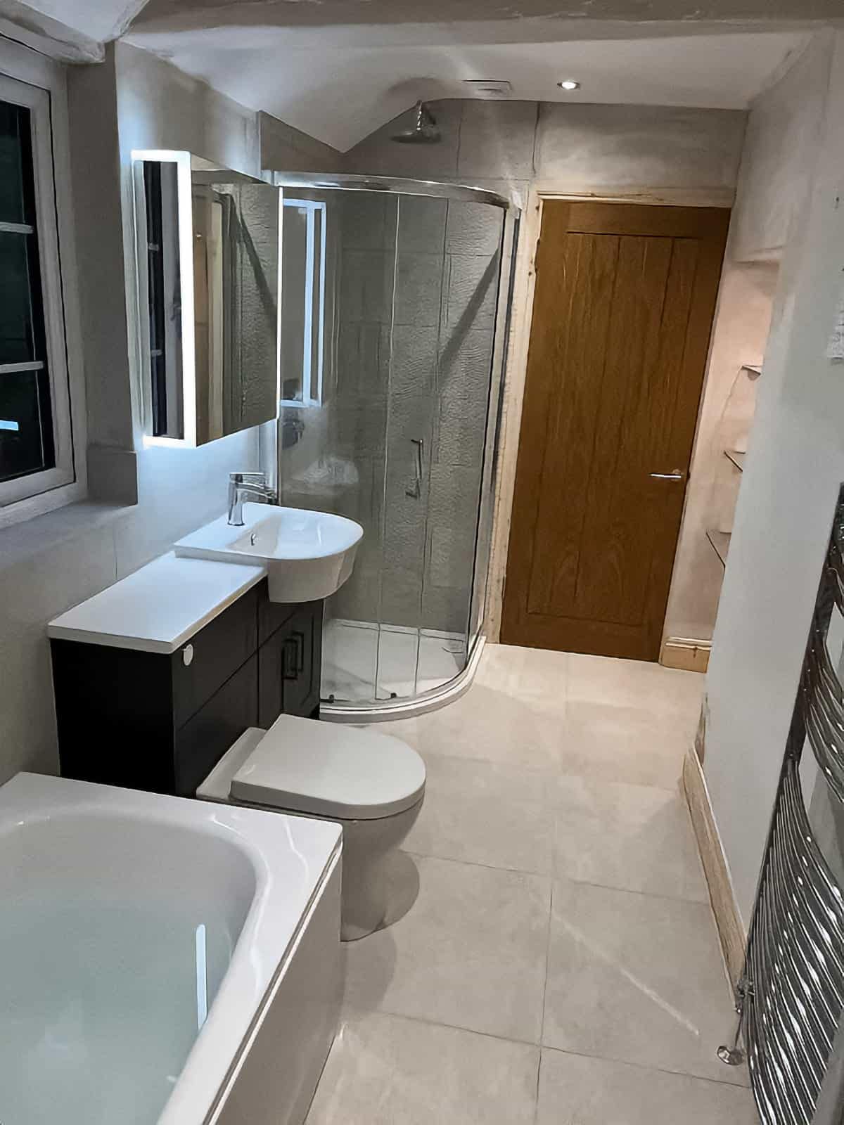 Home Refurbished large bathroom with bathtub, curved shower enclosure, sink and toilet