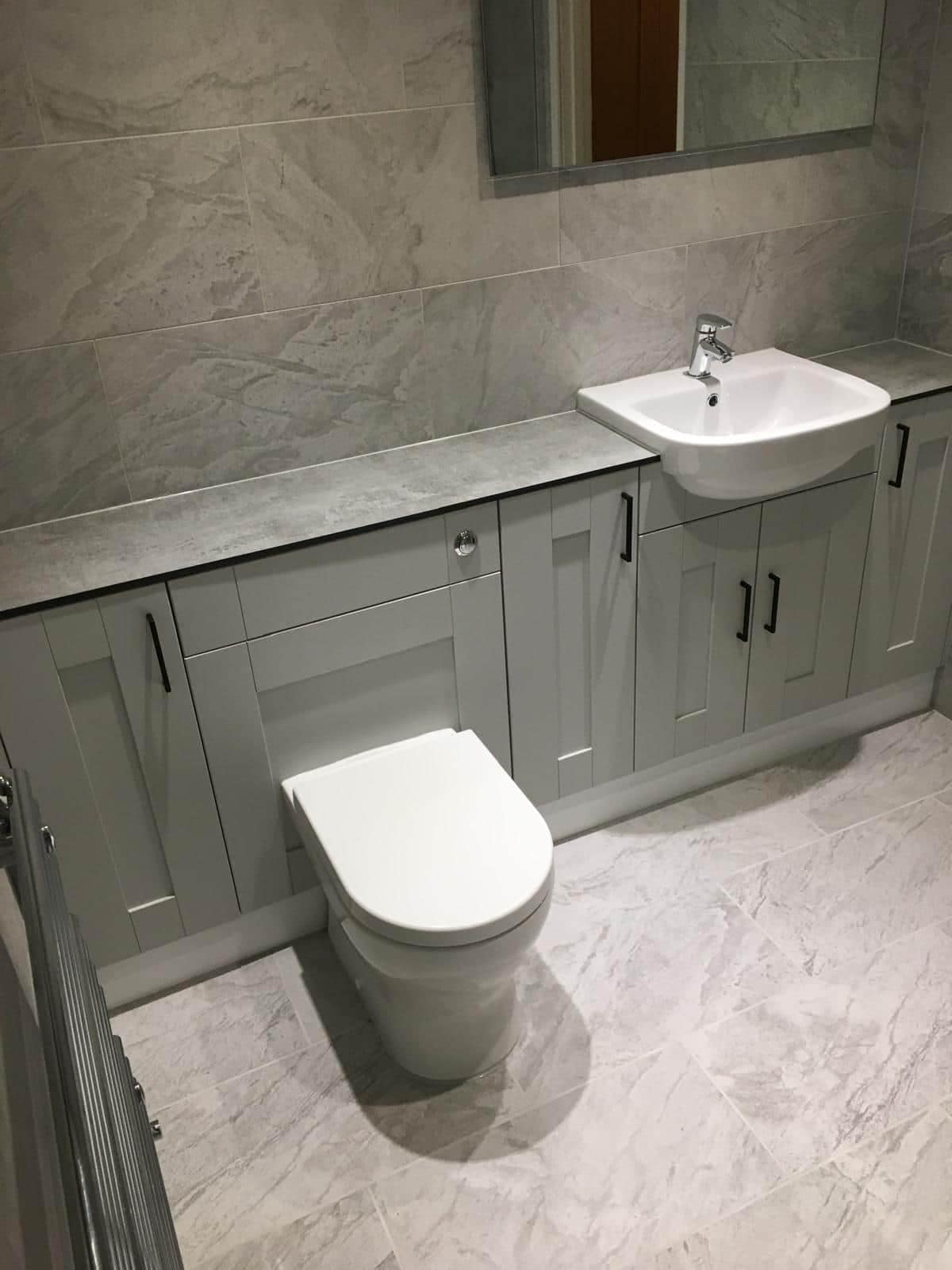 Home Toilet and bathroom vanity unit with large-format grey tiled walls and floor