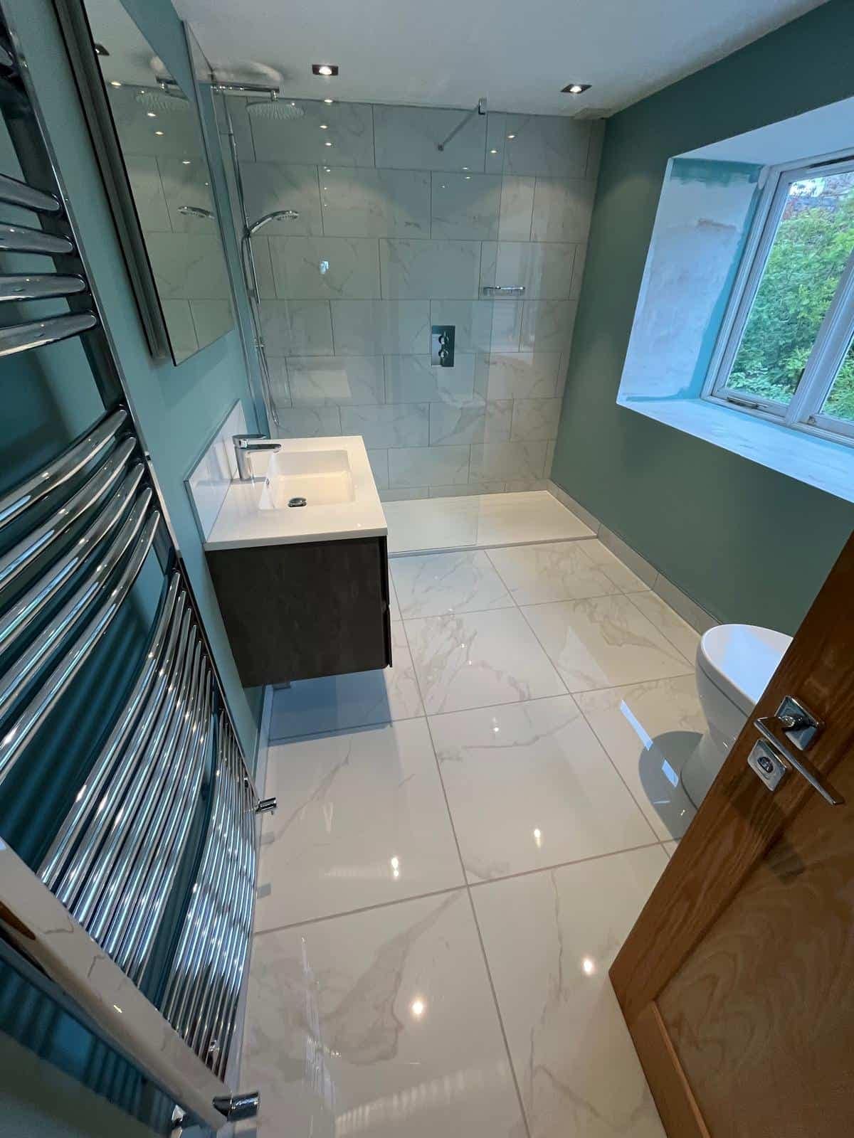 Home Large bathroom in Minchinhampton with wall-mounted vanity, walk-in shower, tiled walls and heated towel radiator