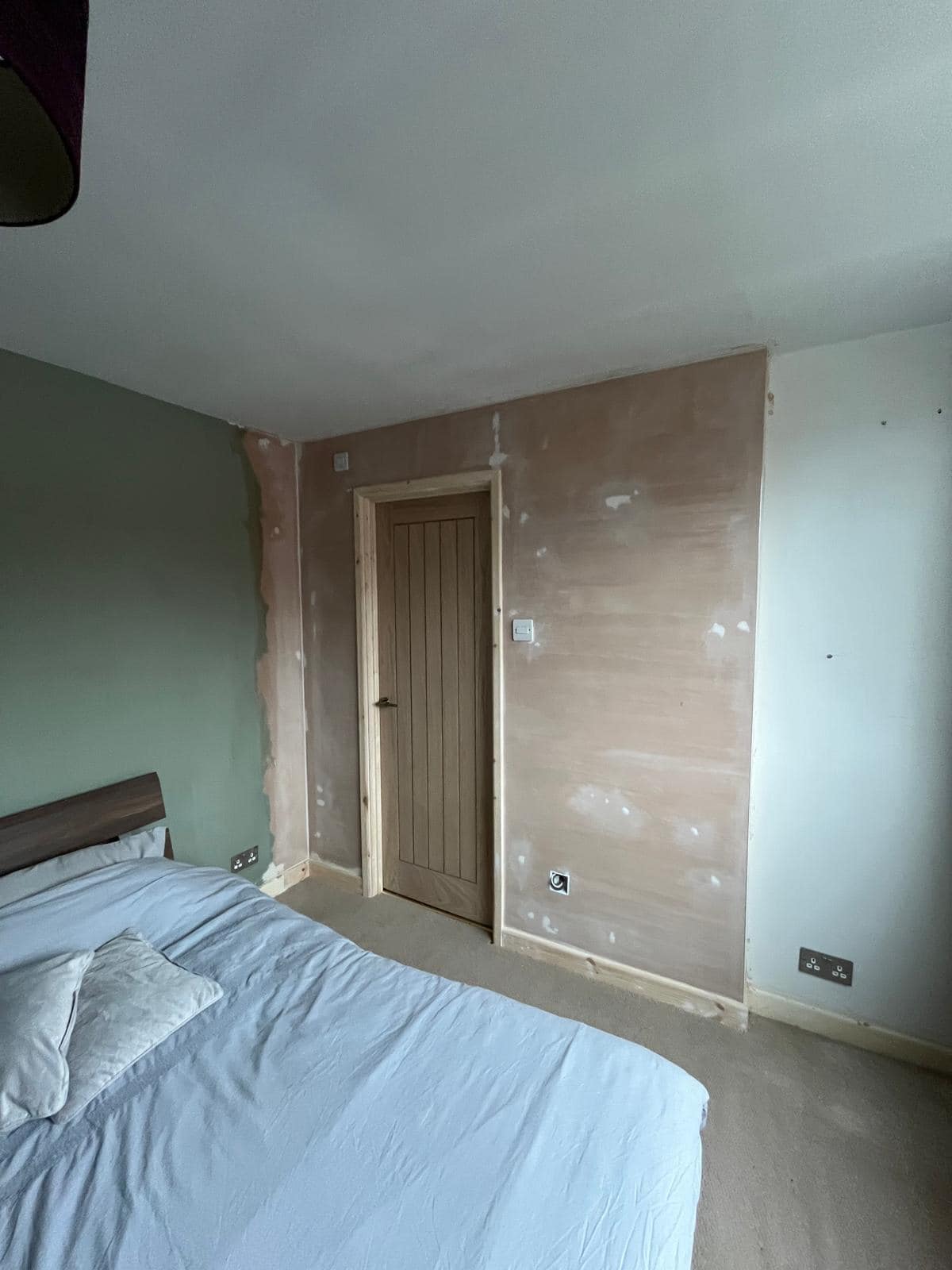 Home Bedroom in Gloucester following construction of a new ensuite, showing the finished partition wall and wooden bathroom door