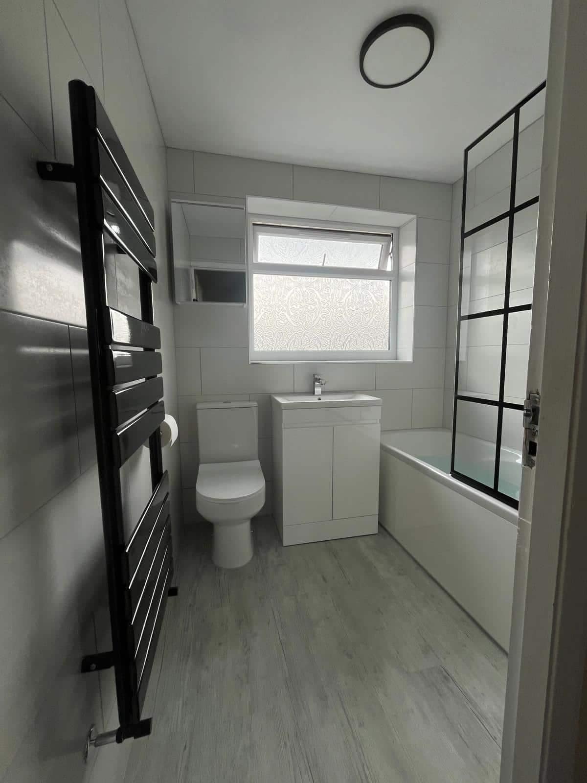 Home Compact bathroom with bathtub shower beside a toilet and vanity with a towel radiator