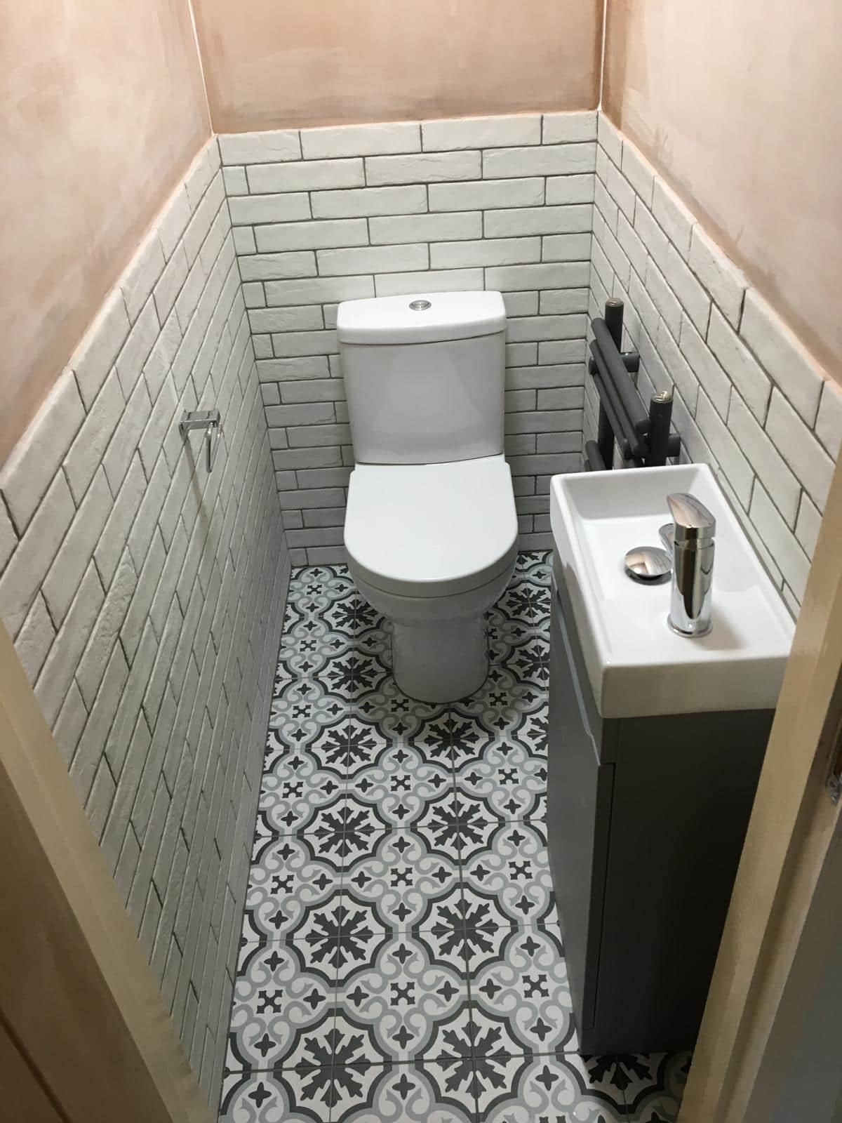 Home Cloakroom with toilet, basin and patterned floor tiles