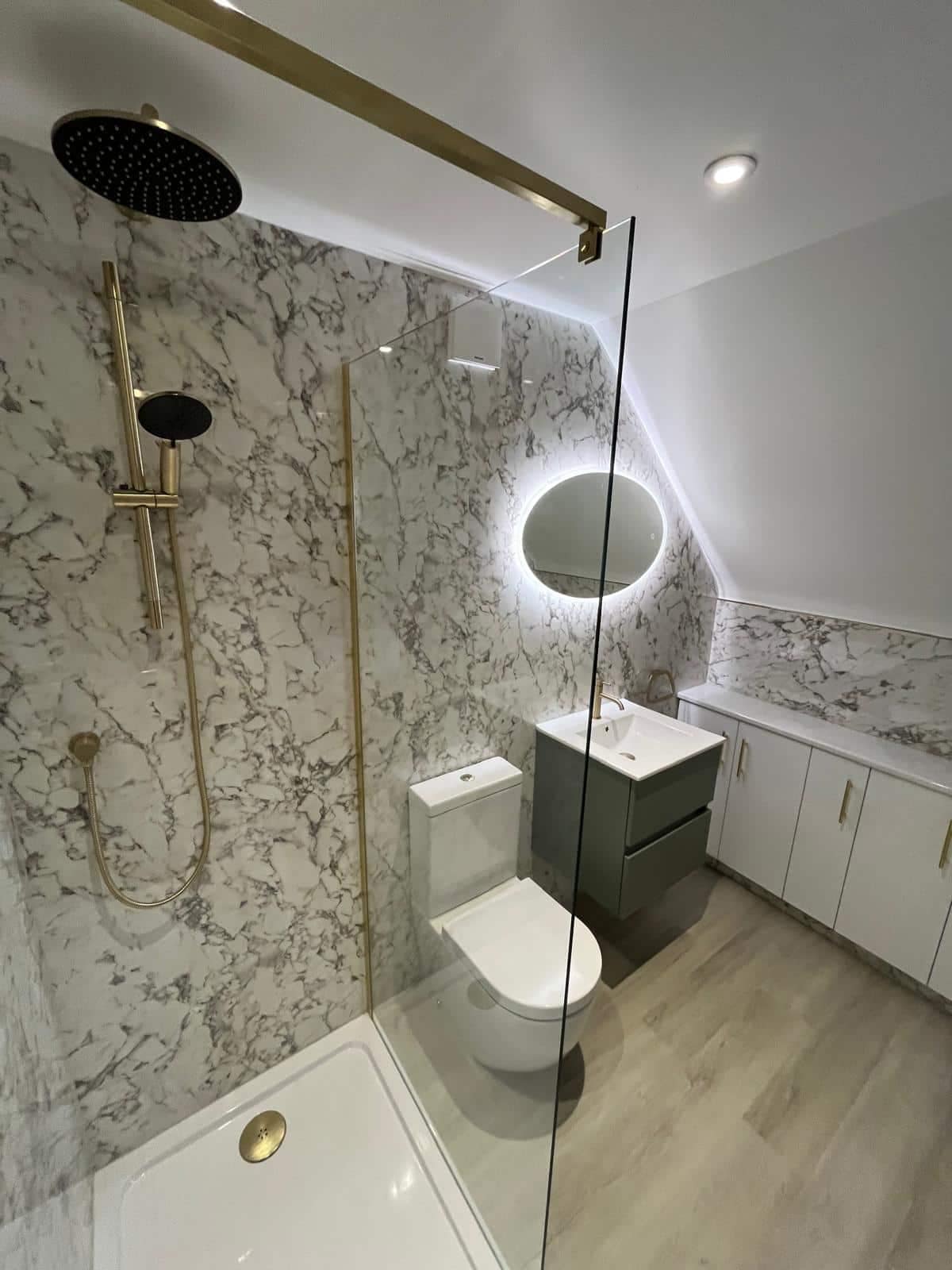 Home Walk-in shower with glass screen and wall-mounted controls beside a toilet and vanity unit